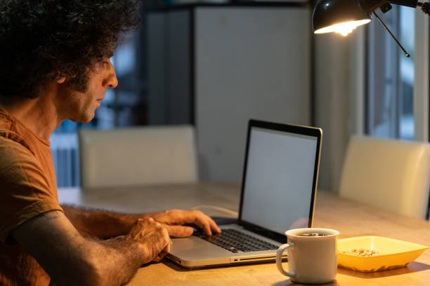 istock Adult Man With Curly Hair Using Notebook Computer At Home 1271200945