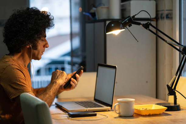 istock Adult Man With Curly Hair Using Notebook Computer At Home 1271201844