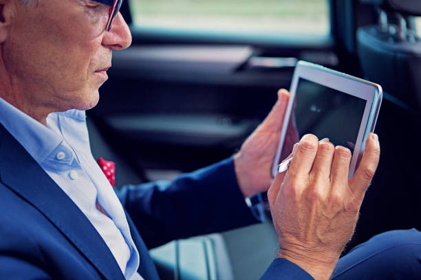 istock Businessman is using digital tablet in a car 1271202569