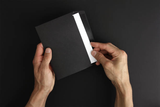 istock hands holds blank black envelopes with white letter on black background, receive post message, mockup, copy space 1271202874