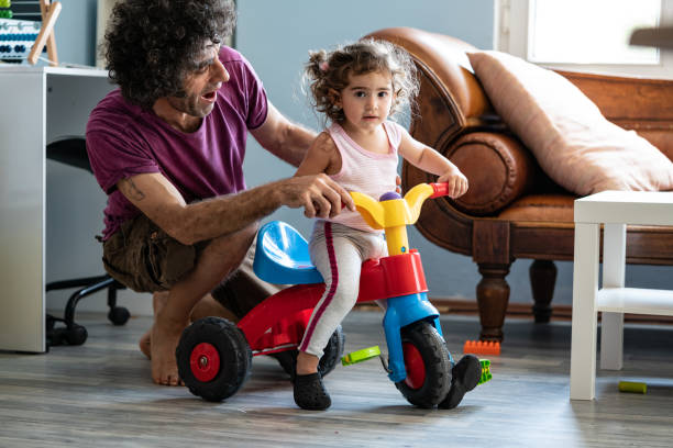 istock Father Teaching Baby Daughter Riding Tricycle 1271203016