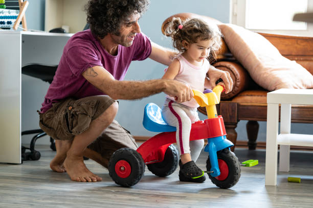 istock Father Teaching Baby Daughter Riding Tricycle 1271204046