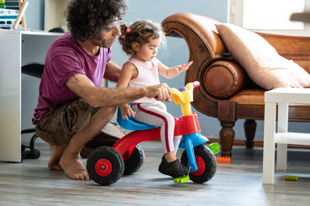 istock Father Teaching Baby Daughter Riding Tricycle 1271204068