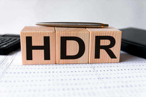 istock HDR word made from wooden cubes on a white business statistics background between a black notebook and a calculator. Business concept 1271204234