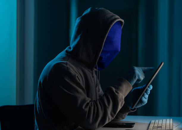istock Man Wearing Hooded Shirt And Mask Using Laptop In Dark To Hack 1271208202