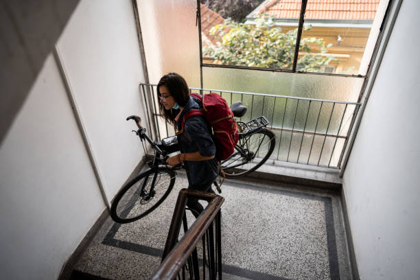 istock Woman carrying her bicycle down the stairs 1271208842