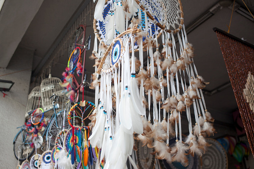 Various feather dream catchers made from the evil eye and souvenir magnets hanging on the walls and roof are sold in the market shop