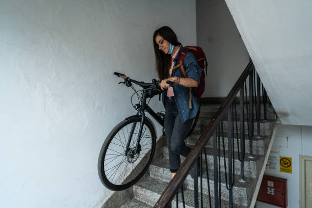 istock Woman carrying her bicycle down the stairs 1271209979