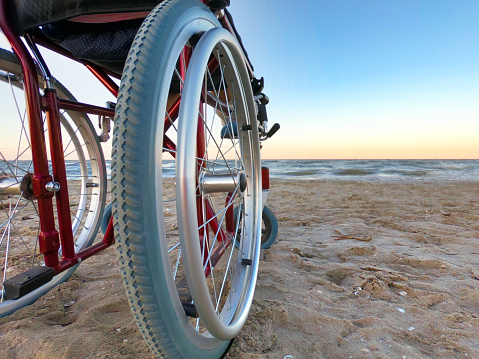 One wheelchair stands by the sea at sunset.Copy space