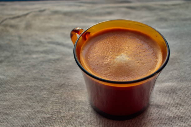 Cup of coffee top view. On a dark background and in semi-darkness. A beautiful drawing of the foam. Close