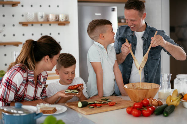istock Mother and father making breakfast with sons. 1271215700