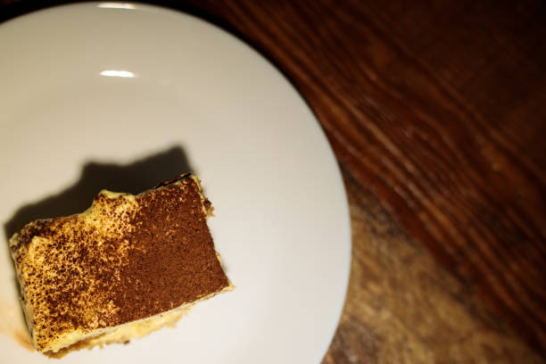 istock Tiramisu slice on white plate on wooden table 1271219487