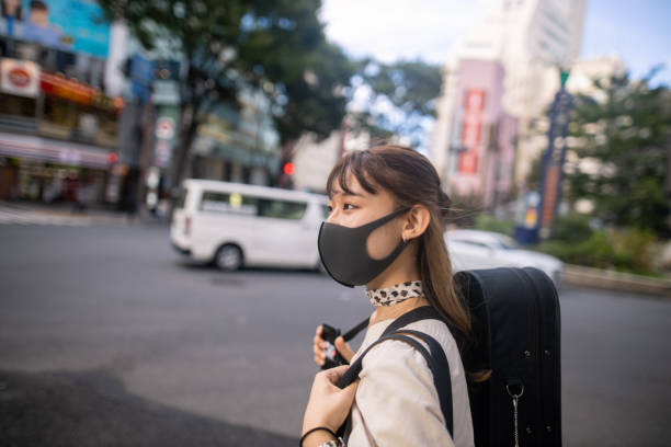 istock Female university student with protective face mask walking in city 1271224832