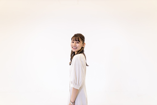 Portrait of young woman against white background