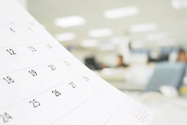 istock Close up white paper desk calendar on table with blurred office interior background 1271230138