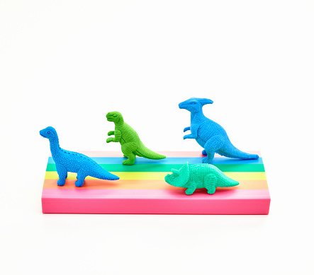 Cute dinosaurs racing on rainbow colored road
