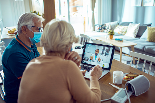 Close up of a senior couple consulting with their doctor online on their laptop