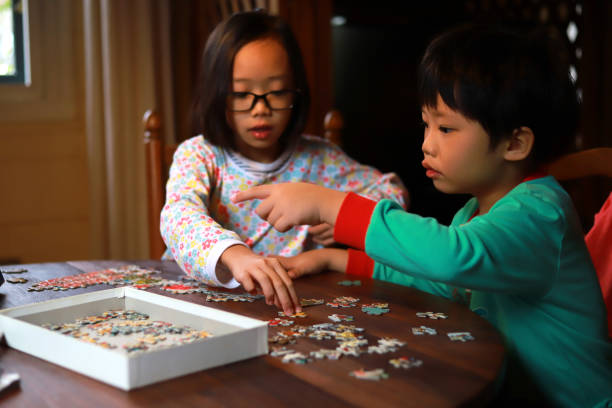 istock Little Sibling Playing Jigsaw Puzzle At Home 1271259024