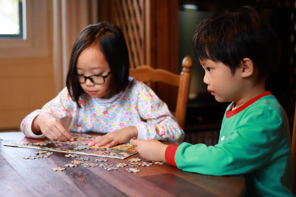 istock Little Sibling Playing Jigsaw Puzzle At Home 1271259662