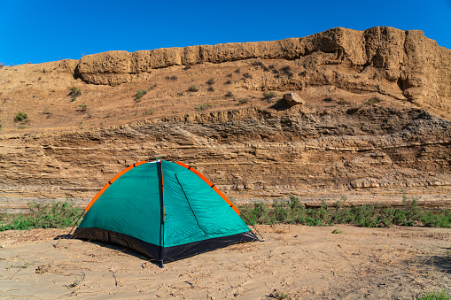 Tourist tent in a mountainous desert area by a small river