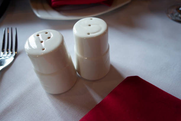 istock salt and pepper ceramic white spice shakers on a table with table setting 1271263134