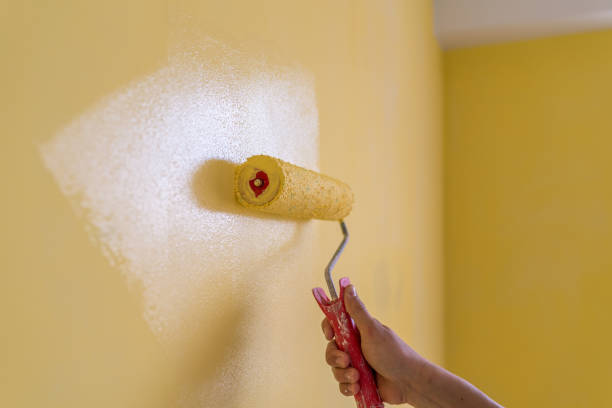 istock Workman painting the wall in yellow. 1271265775