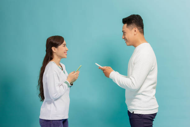 istock amazing couple whose use smart phone read news look with interest isolated light blue background 1271267977