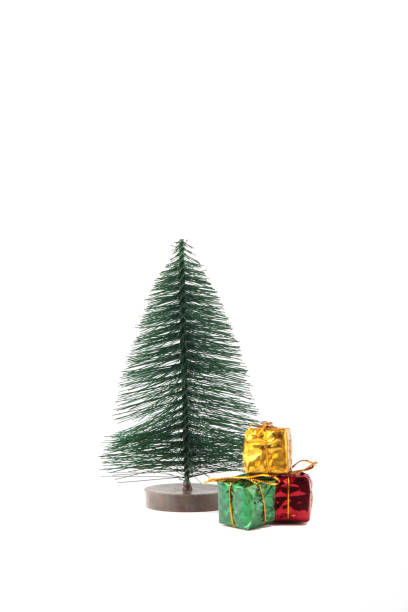 istock wrapped christmas presents under a fir tree isolated on white background. Christmas gift concept. Vertical image 1271270596