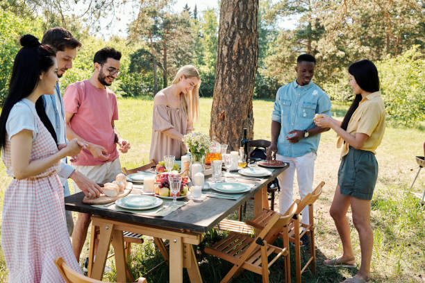 istock Large group of young intercultural friendly people standing under pine tree 1271270711