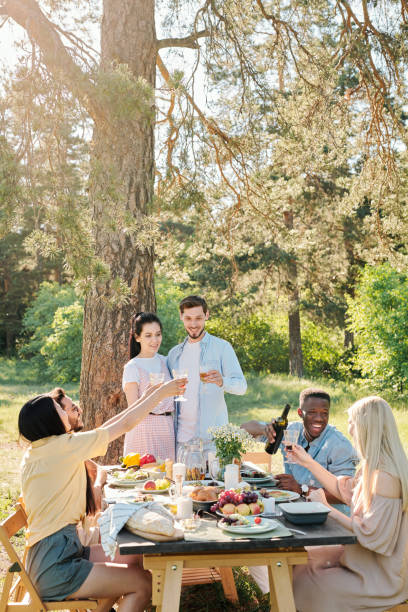 istock Three multicultural couples clinking with glasses of wine over served table 1271270766