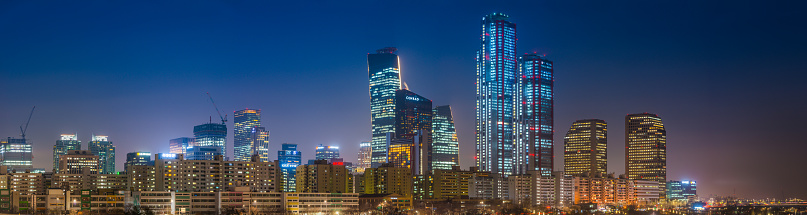 The skyscrapers of Yeouido glittering in the neon night of downtown Seoul across the Han River in the heart of South Korea’s vibrant capital city.