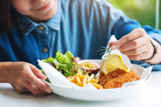 a female chef cooking and decorating a dish of fish and chips