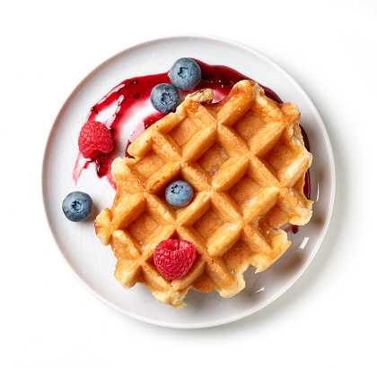 dessert of belgian waffle and fresh berries isolated on white background, top view