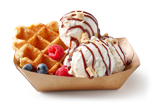 belgian waffle with fresh berries and vanilla ice cream in paper take away tray isolated on white background