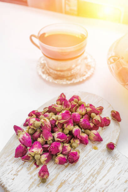 чай из розовых бутонов . почки чайной розы сделаны из настоящих розовых почек, сорвали молодые, а затем сушеные. чашка чая и прозрачный чайни - tea rose tea crop scented стоковые фото и из�ображения