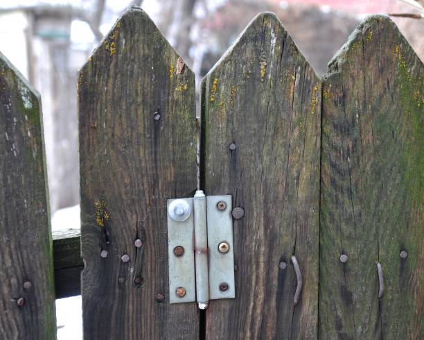 istock Old wooden fence with hammered bent nails, a loop from the gate. 1271274423