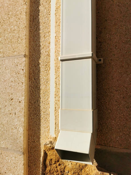 istock white plastic drain pipe on the brown brick wall. Downspout 1271274433