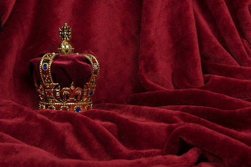 Corona dorada sobre fondo de terciopelo rojo photo