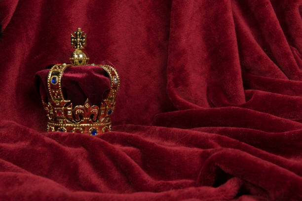 corona dorada sobre fondo de terciopelo rojo - coronation fotografías e imágenes de stock