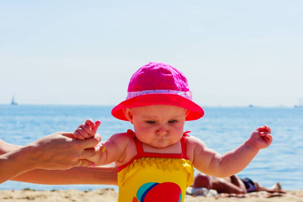 istock Child holding adult hands on beach 1271276618