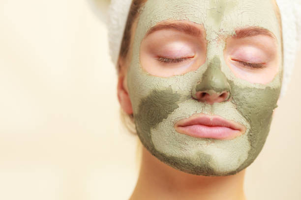 istock Woman face with green clay mud mask 1271276820