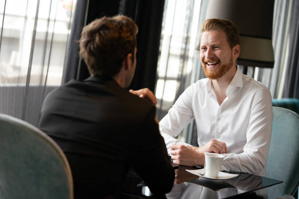 istock Coffee break. Two cheerful business men talking in a restaurant 1271277197