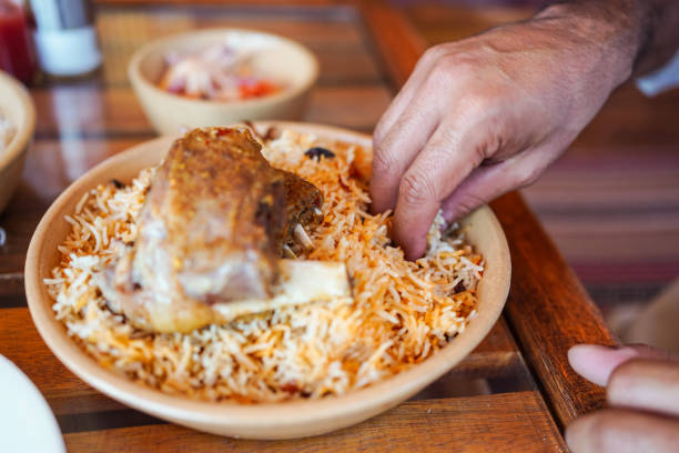 istock Man eating using hand a traditional biryani rice and chicken dish in local restaurant 1271278069