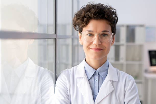 молодая успешная работница научной лаборатории в плаще и очках - scientist chemist doctor lab coat стоковые фото и изображения