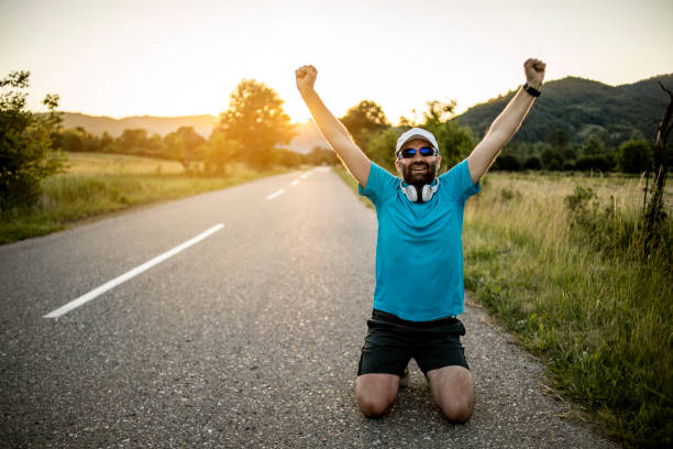 istock Athlete doing exercises on the road in nature - An athlete who runs outdoors for exercise and fitness - Athletic Man Doing Running 1271280252
