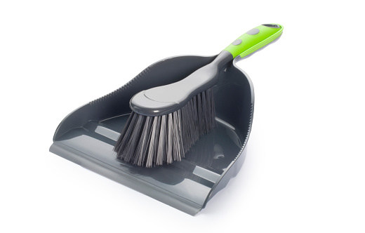 Studio shot of a dustpan and brush cut out against a white background.