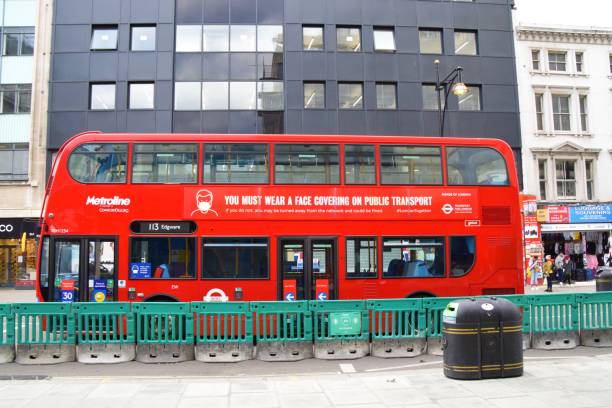 Face covering information on a red double-decker bus in London London, United Kingdom - August 26 2020: Information on face covering on the side of a red double-decker bus on Oxford Street soho billboard stock pictures, royalty-free photos & images
