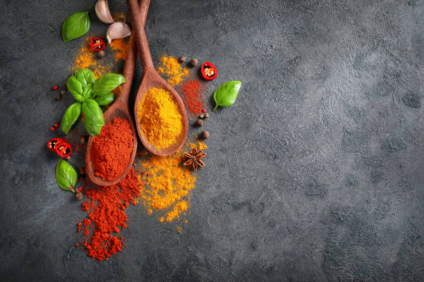 istock Wooden spoons with spices and herbs on dark background. Top view. Copy space. 1271284016