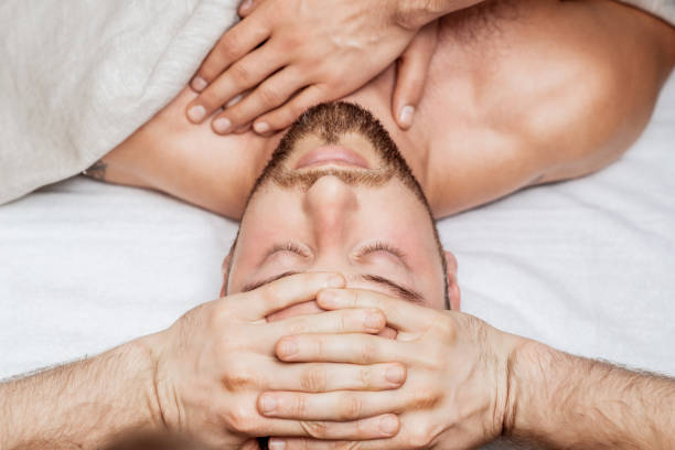 istock Man receiving head massage by two masseurs 1271284031