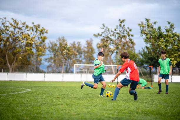 calciatori adolescenti dribbling e difesa in pratica - gara sportiva giovanile foto e immagini stock